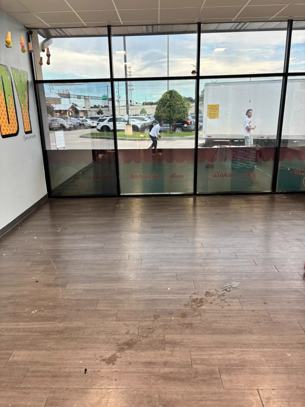 Cleared commercial shop floor facing the storefront windows