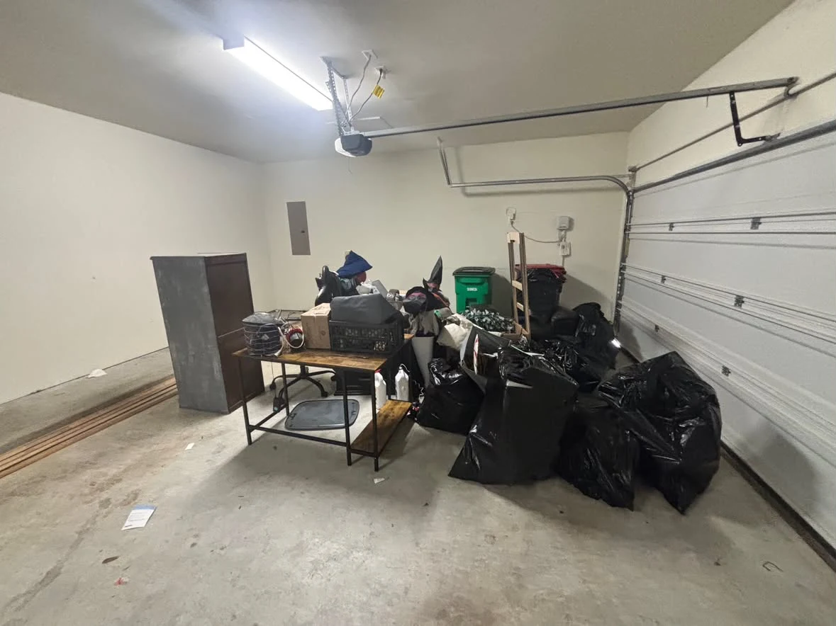 Garage with bags, chairs and clutter before 005 Haul's cleanout