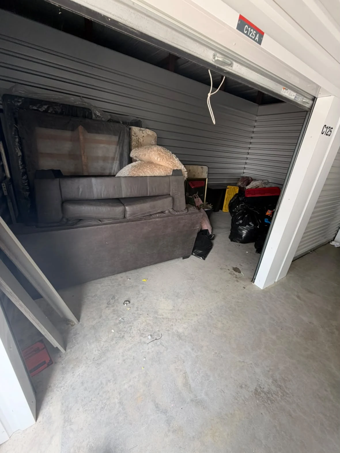 Storage unit filled with mattresses and furniture before cleanout