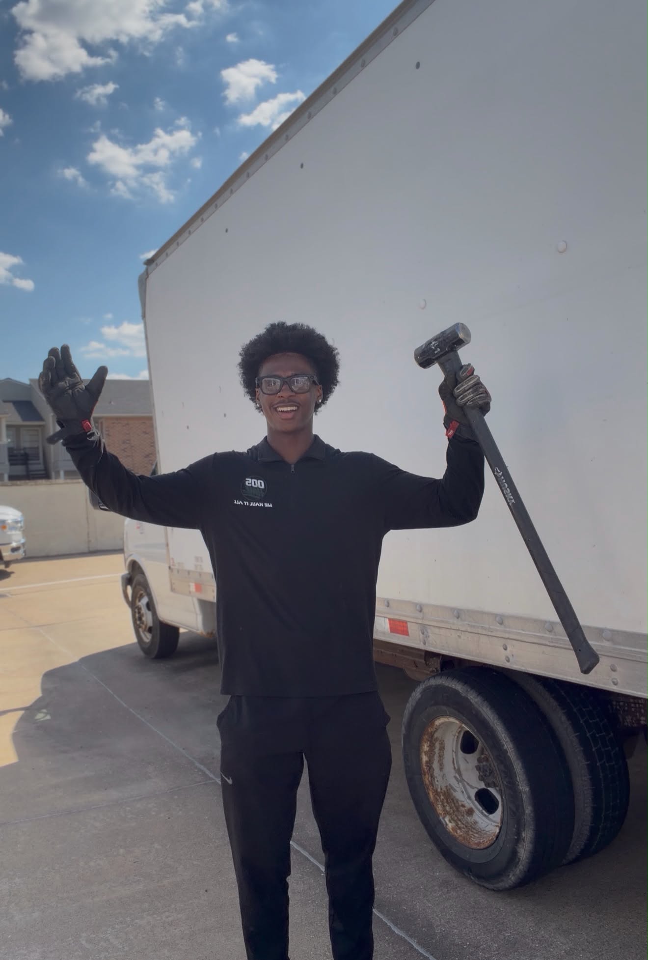 Rasaan, owner of 005 Haul, smiling beside his work truck